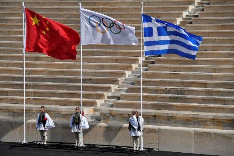 Los guardias presidenciales griegos izan las banderas olímpica, china y griega durante la ceremonia de entrega de la llama olímpica en el Estadio Panathinean en Atenas este martes.
