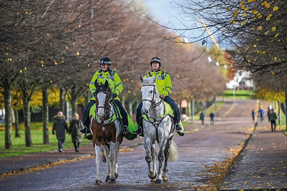 SEGURIDAD. Policías británicos patrullan a caballo por una avenida de la ciudad de Glasgow.