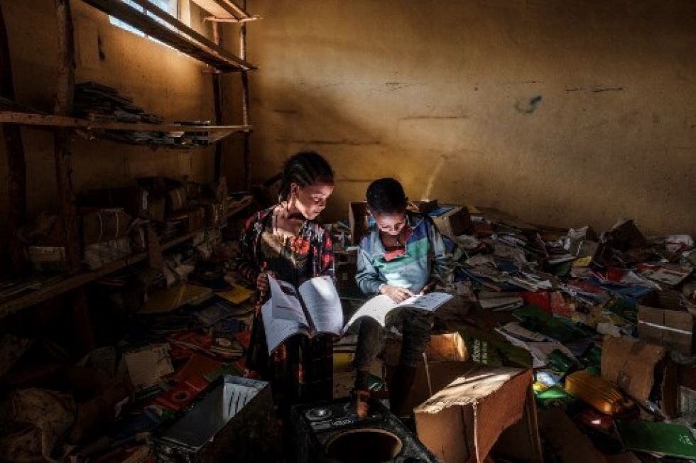 Dos niños etíopes leen bajo una tenue luz en un campo de refugiados. La violencia política asola desde hace varios meses a ese país del norte africano.