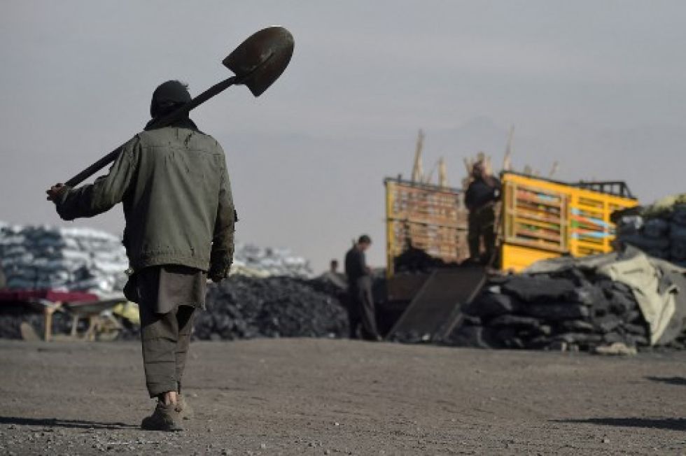 Un trabajador afgano camina cerca de un depósito de almacenamiento de carbón, un combustible muy requerido en la temporada invernal.