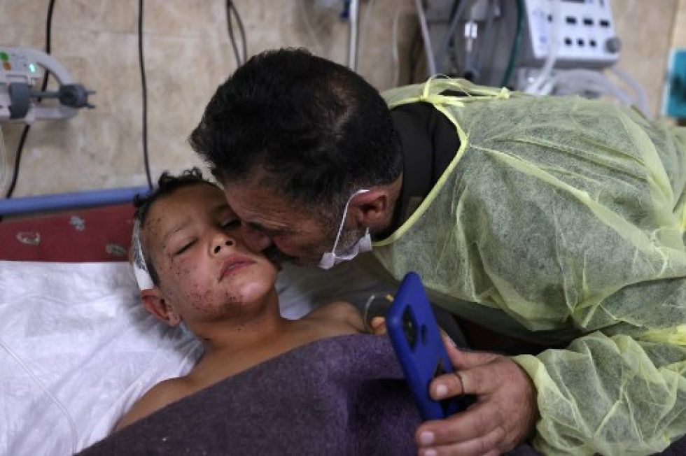 Ahmad Qassum visita a su pequeño hijo en el hospital, quien todavía sufre las secuelas del ataque aéreo.