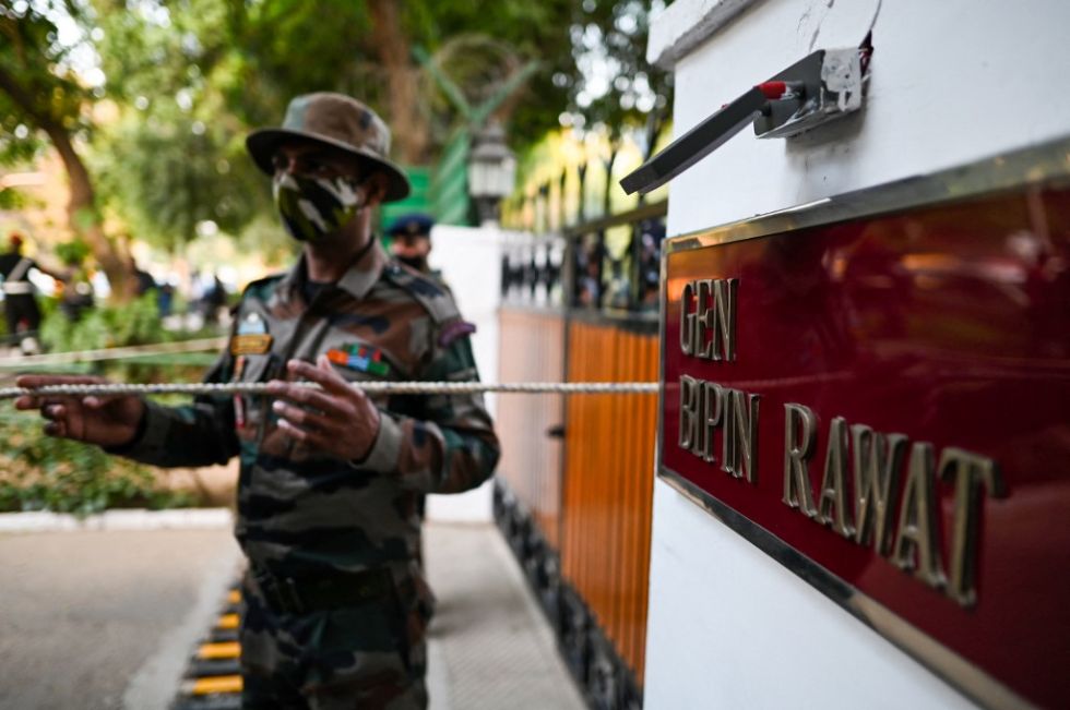El personal de seguridad y medios de comunicación frente a la casa del general Bipin Rawat.