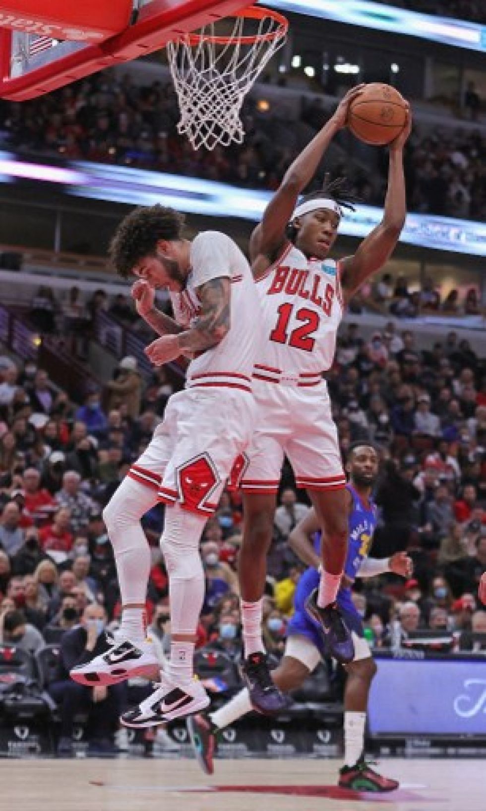 Ayo Dosunmu (#12) de los Chicago Bulls rebota sobre su compañero Lonzo Ball (#2) contra los Denver Nuggets en el United Center el 6 de diciembre.