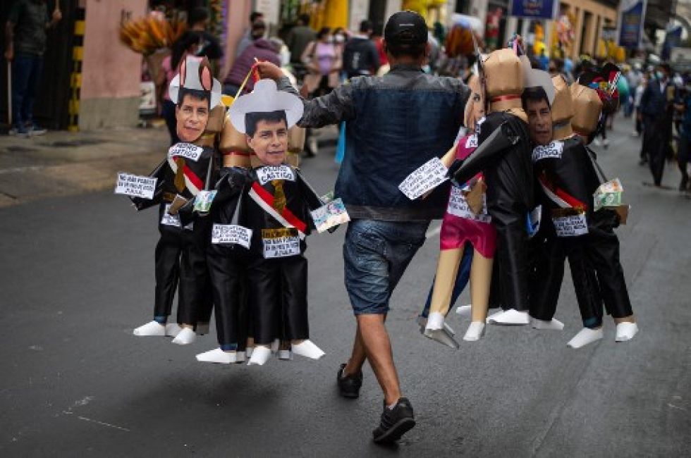 Un comerciante ofrece muñecos con la figura del actual presidente peruano, Pedro Castillo, en vísperas de las celebraciones de Año Nuevo.
