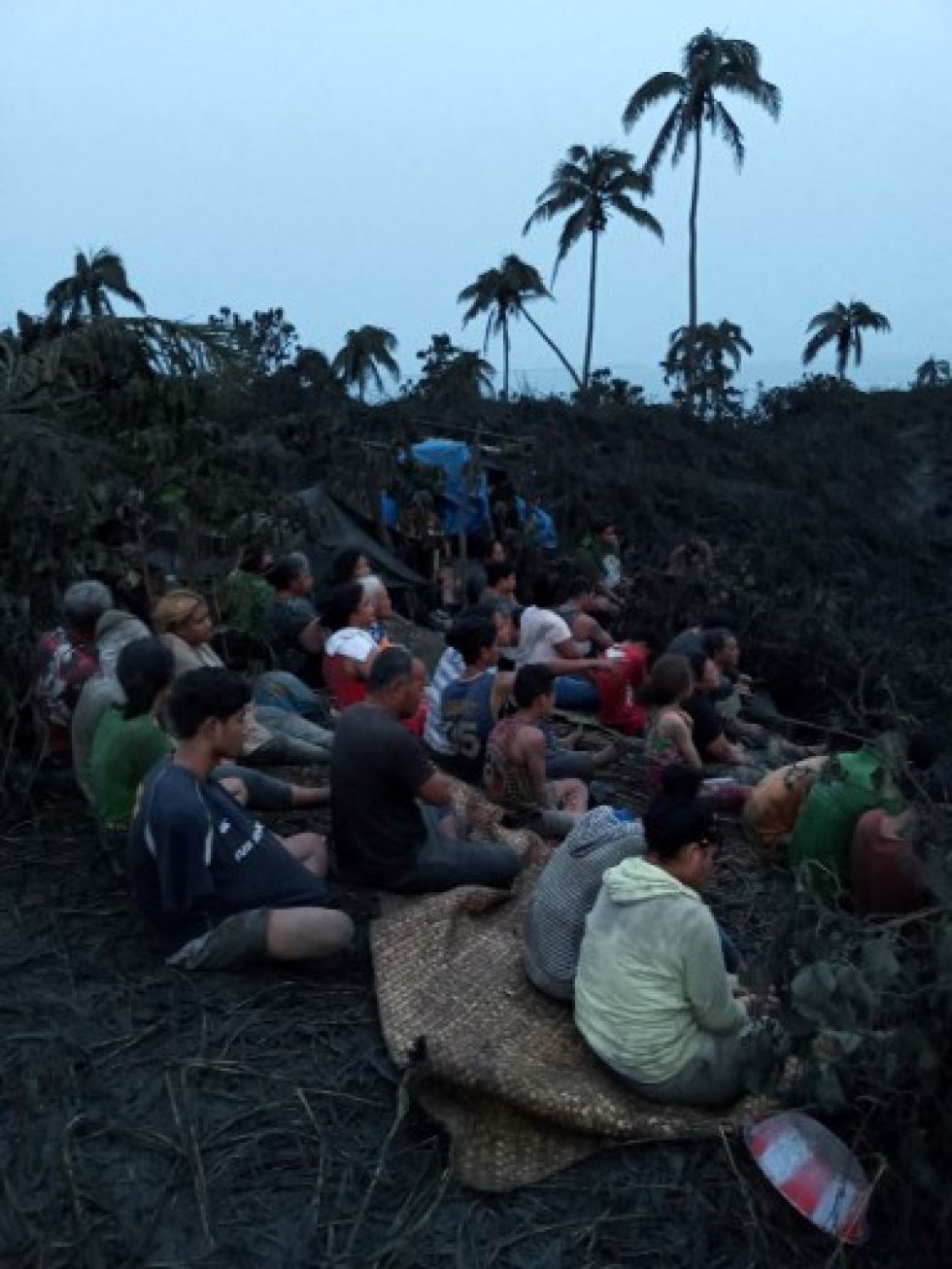 Sobrevivientes rezando en la cima de una colina al amanecer en la isla Mango, luego de la erupción del 15 de enero del cercano Hunga Tonga-Hunga Ha. Volcán submarino 'apai.