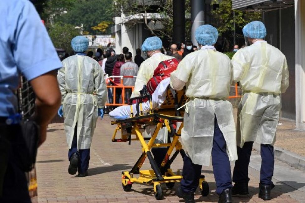 Médicos de ambulancia con ropa protectora contra el covid-19 ingresan a una urbanización donde se descubrió un grupo reciente de casos de coronavirus.