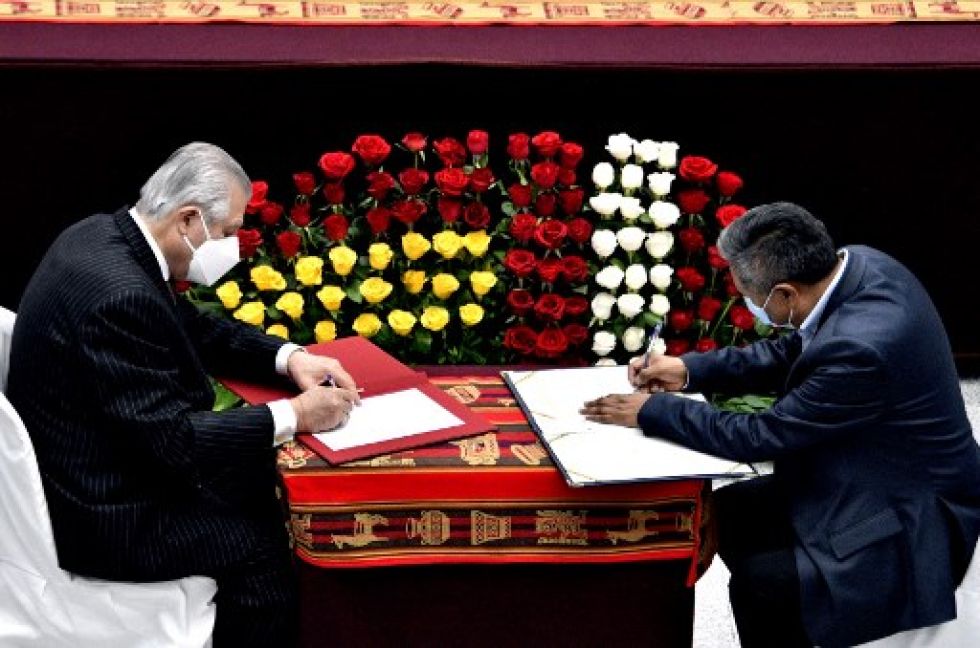Óscar Maurtúa (i) firma con su par boliviano, Rogelio Mayta, un documento conjunto durante una reciente reunión binacional de ambos gobiernos.