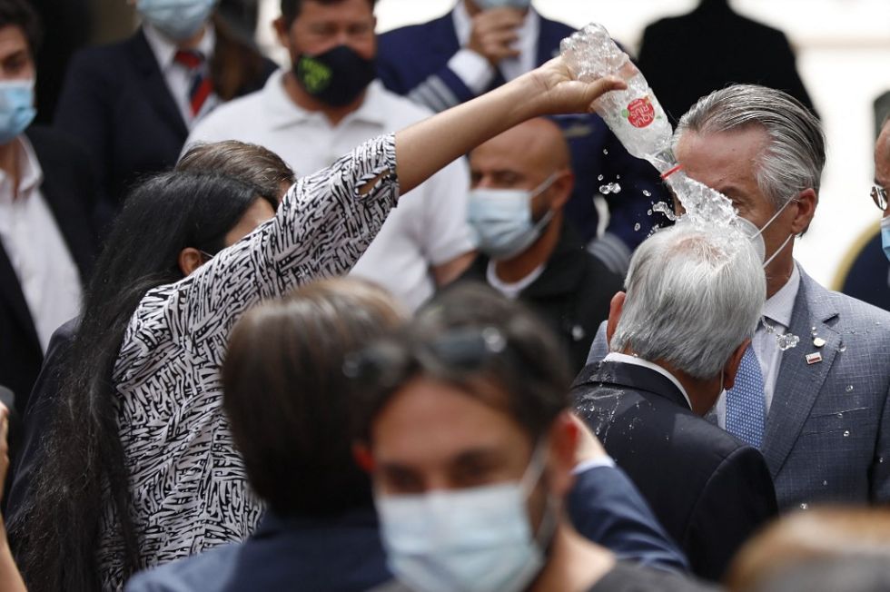 El momento exacto en el que la mujer lanza agua al presidente chileno Sebastián Piñera. 