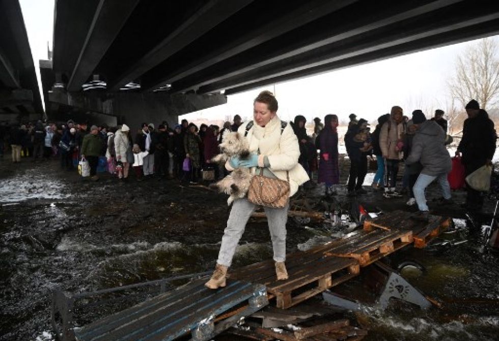 Una mujer ucraniana carga a su mascota durante una operación de civiles al norte de Kiev.