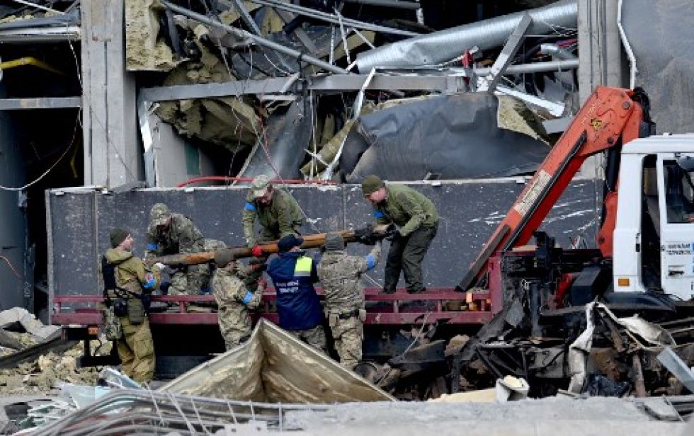 Militares ucranianos cargan un fragmento de un cohete en un camión frente a un edificio en Kiev el 24 de marzo de 2022.