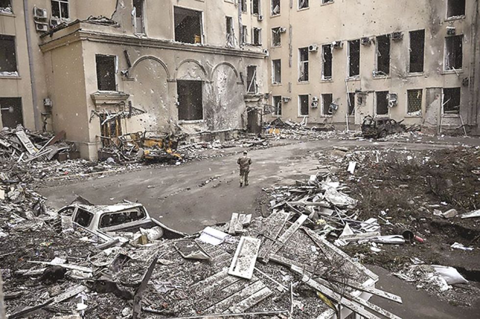 GUERRA. Un militar ucraniano camina entre los escombros de la sede regional destruida de Kharkiv.