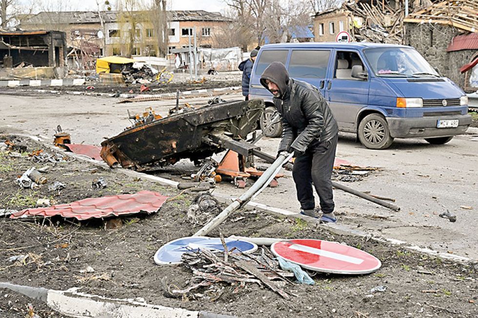 GUERRA. Habitantes del norte de Kiev remueven escombros en una calle, días después del retiro de las tropas rusas.