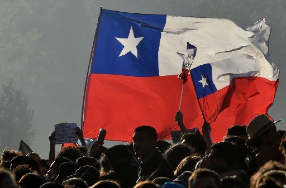 Chilenos ondean banderas durante una protesta en contra del entondes presidente, Sebastián Piñera.