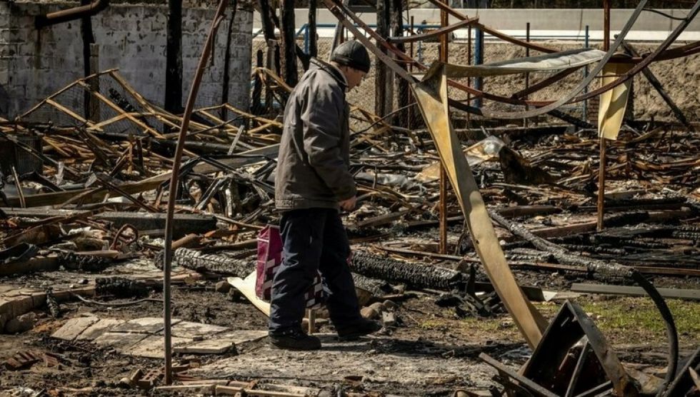 Un hombre camina entre los escombros de una casa destruida en el pueblo ucraniano de Zalissya, al noreste de Kiev.