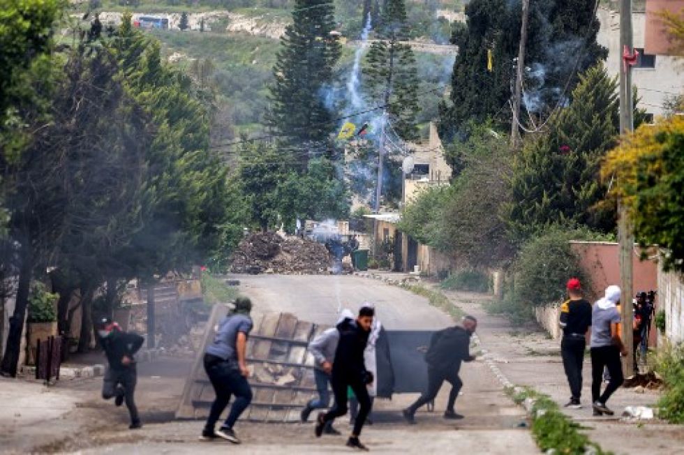 Fuerzas israelíes disparan gases lacrimógenos contra los manifestantes palestinos que se reúnen contra una marcha de los colonos israelíes hacia el asentamiento salvaje de Homesh.