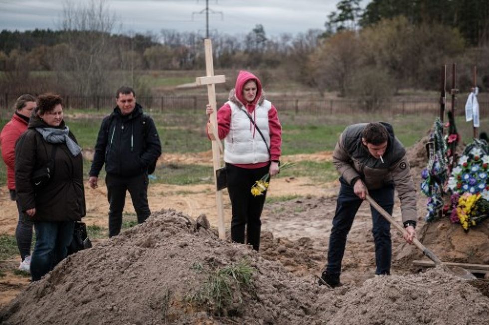 Familiares de Mykhailo Romaniuk, de 58 años, asesinado a tiros en su bicicleta el 6 de marzo, entierran su ataúd en un cementerio de Bucha, este martes.