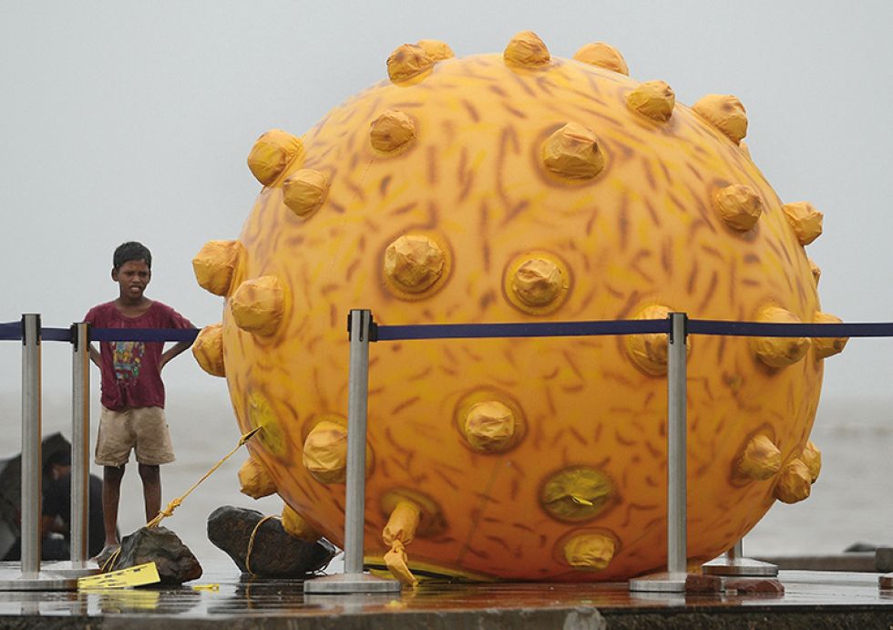 SENSIBILIZACIÓN. Un niño indio se encuentra cerca de una réplica del virus de la hepatitis.