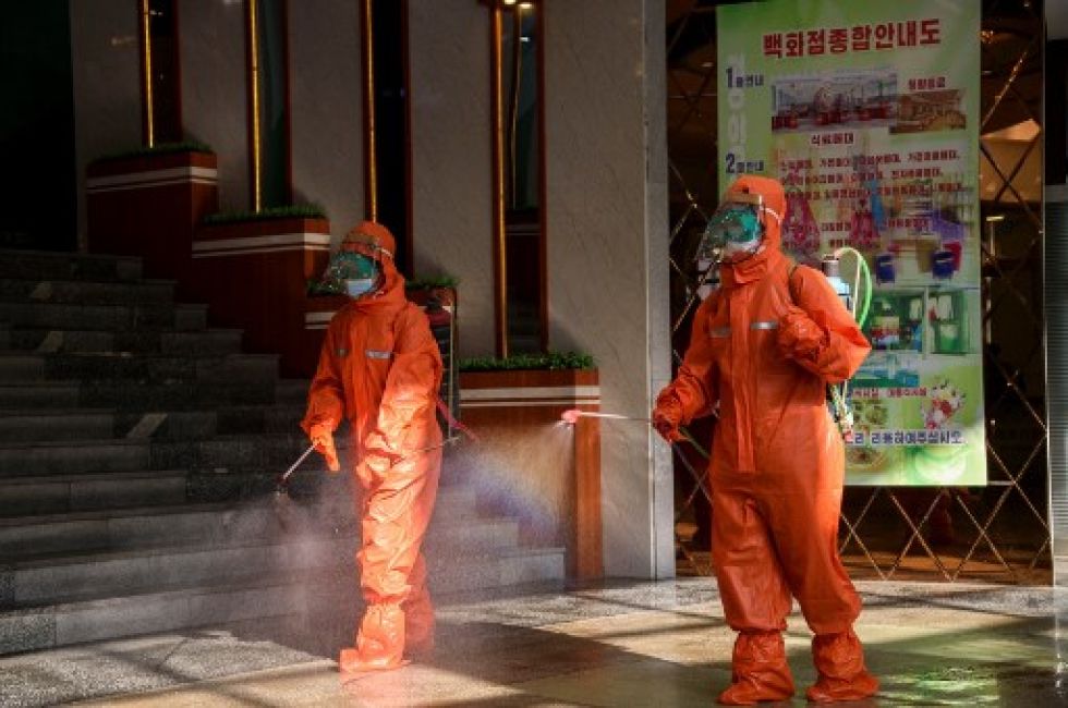 Empleados rocían desinfectante como medida preventiva contra el coronavirus en almacenes Yokjon en Pyongyang.