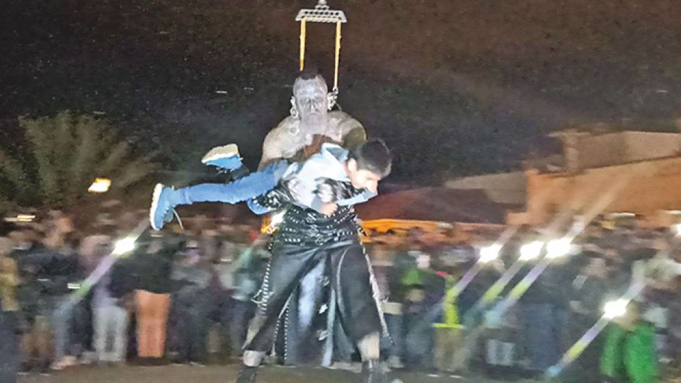 SHOW. El uruguayo Víctor Hugo Peralta suspende a un niño en sus brazos. (En recuadro) y un artista plasma su arte en una pierna.