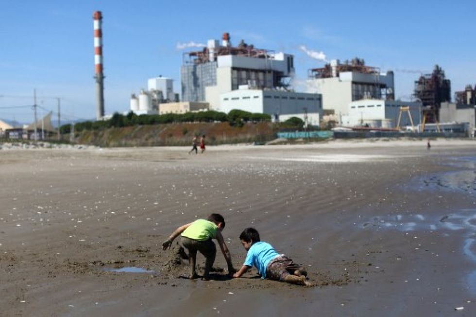 Niños juegan en la arena de la playa Las Ventanas junto a la planta termoeléctrica AES Gener en Puchuncaví, Región de Valparaíso, Chile.