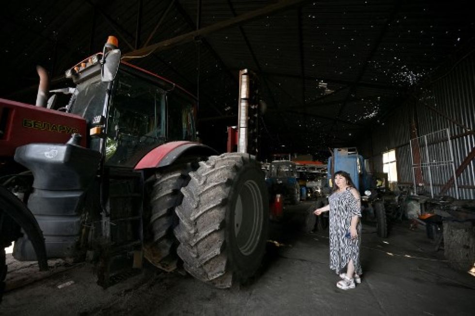 La agricultora Nadia Ivanova en un hangar dañado con maquinaria agrícola dañada.