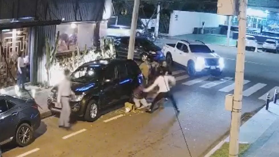 El momento en el que el hombre (camisa blanca) golpea al joven en plena vía pública.