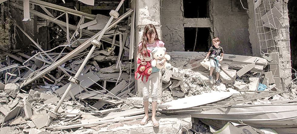DESPROTEGIDOS. Una niña y un niño rescatan objetos de su casa destruida en la Franja de Gaza.
