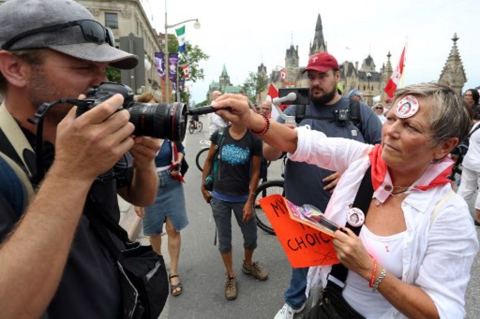 Una manifestante del movimiento antivacunas intenta marcar la cámara de un fotógrafo, durante una manifestación en la ciudad de Ottawa, Canadá.