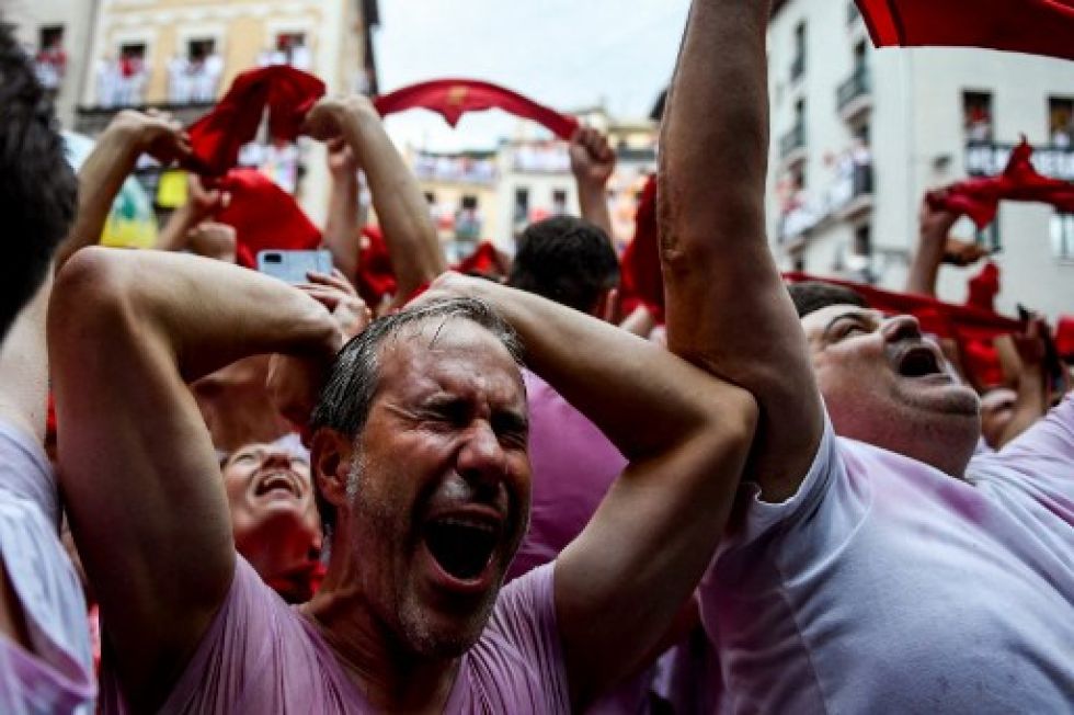 Participantes de la fiesta de San Fermín festejan, en la plaza de Pamplona, el tradicional "Chupinazo" que da comienzo a las celebraciones.