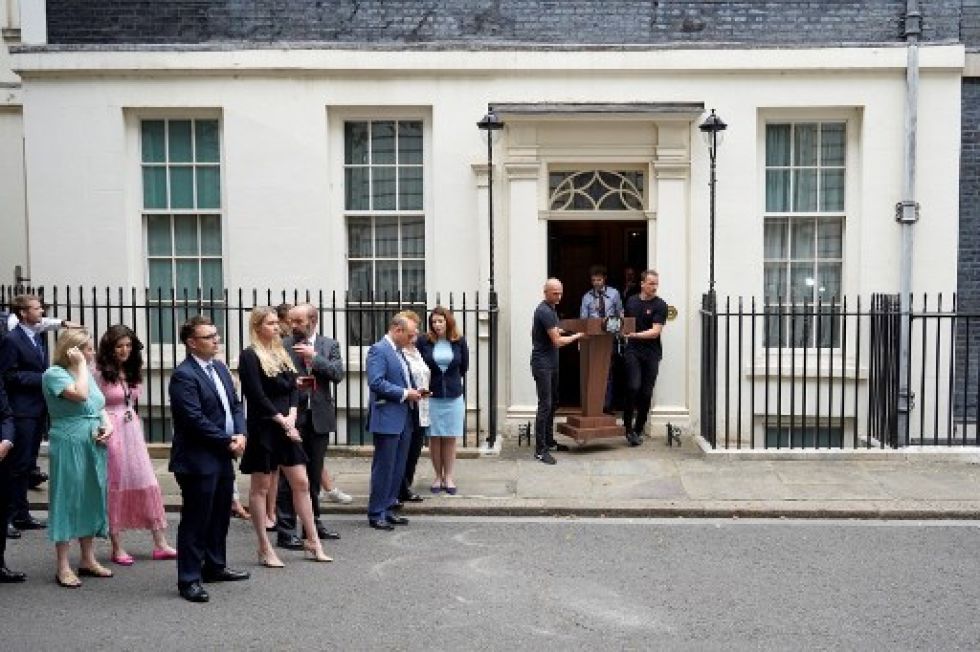 Colaboradores del primer ministro británico, Boris Johnson, aguardan frente a la residencia de Downing Street la intervención del jefe de Estado, quien renunció a su liderazgo.