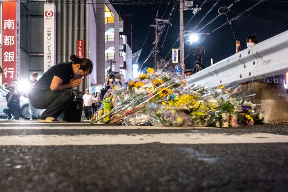 Una mujer reacciona frente a un monumento improvisado fuera de la estación Yamato-Saidaiji en Nara, donde Shinzo Abe recibió un disparo .