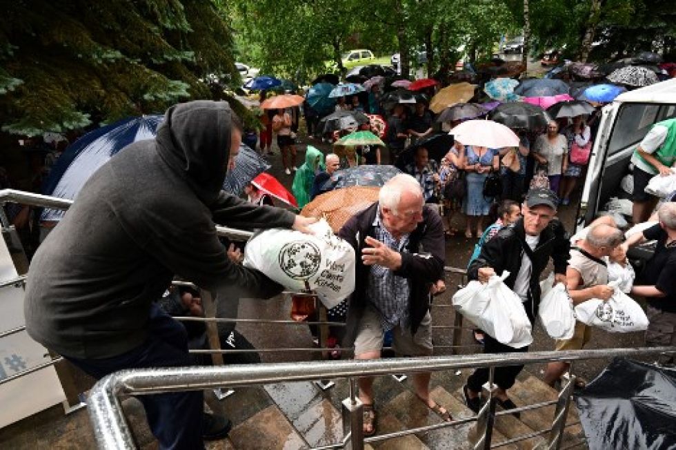 Voluntarios distribuyen comida a la población ucraniana en la ciudad de Kramatorsk, en medio de una persistente lluvia.