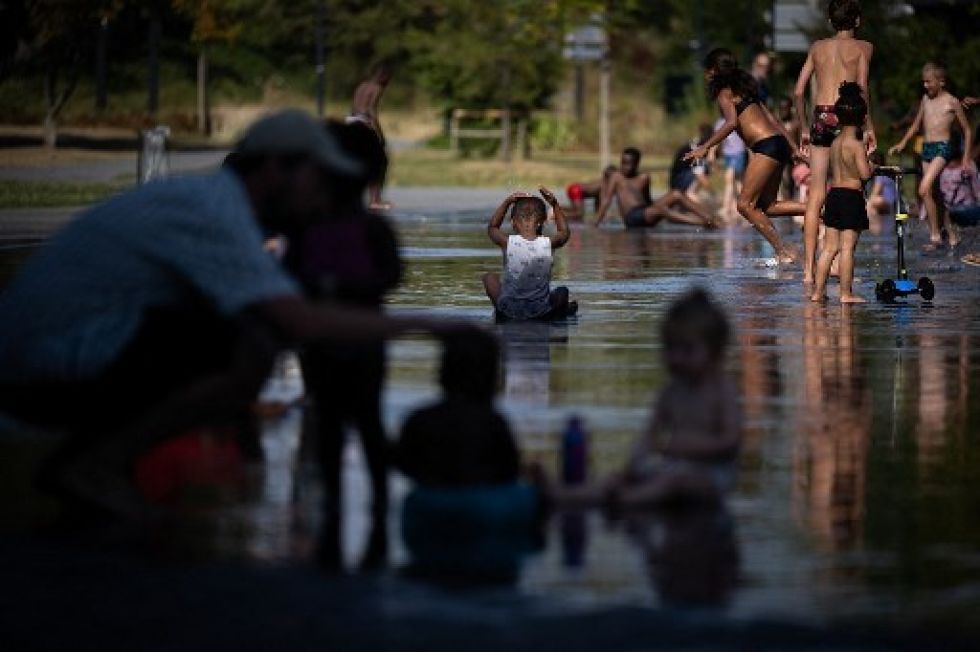 Niños se refrescan con el agua de una fuente en Nantes, el 18 de julio de 2022, cuando la temperatura del aire supera los 42 grados centígrados.