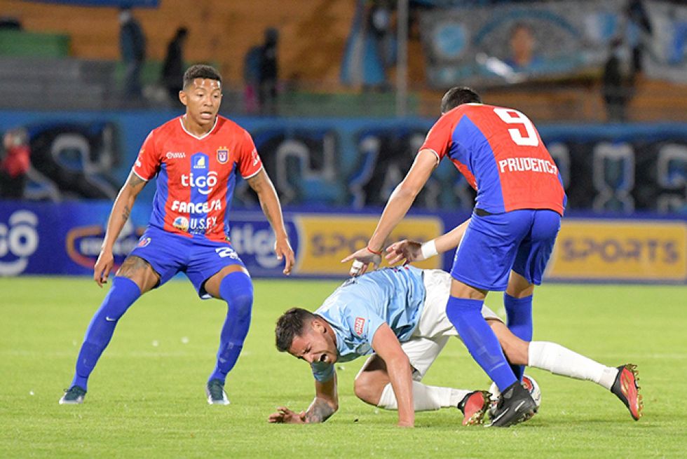 Moisés Calero (i) y Ángel Prudencio (d)marcan a un jugador de Aurora.