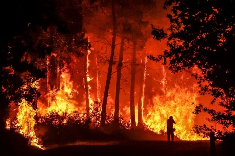 Se ve una silueta frente a las llamas en un incendio forestal cerca de Belin-Beliet, suroeste de Francia.