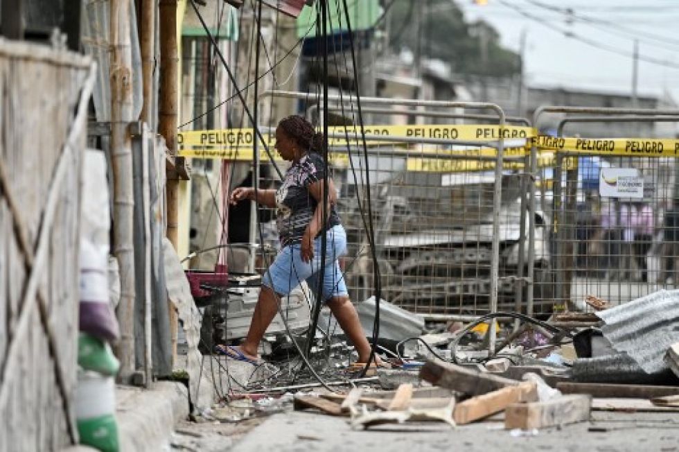 Una mujer camina en medio de escombros dejados por la explosión en el barrio de Samborondón.