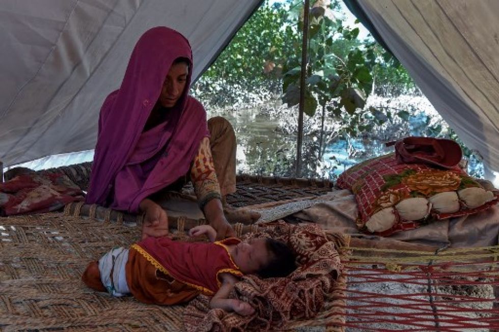 Hajira Bibi, afectada por las inundaciones, se sienta con su hija dentro de una tienda de campaña cerca de su casa inundada.