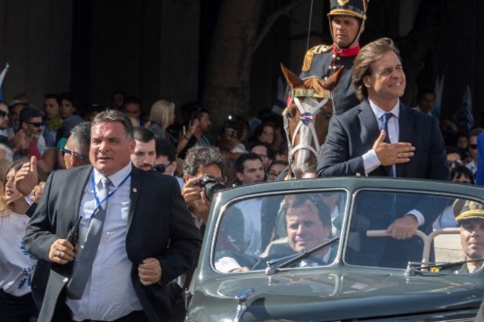 El jefe de la guardia presidencial, Alejandro Astesiano (i), corre junto al presidente de Uruguay, Luis Lacalle Pou.