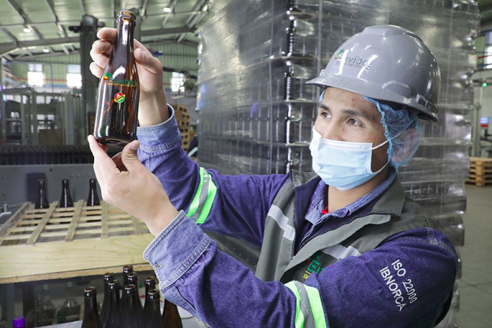 PRODUCCIÓN. Un operador muestra una botella de vidrio producida en la planta de Zudáñez.