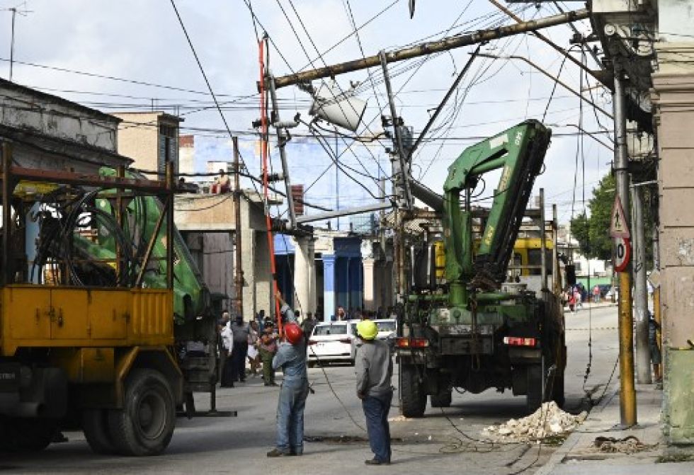 Trabajadores de la empresa eléctrica cubana reparan líneas eléctricas tras el paso del huracán Ian en la región El Cerro.