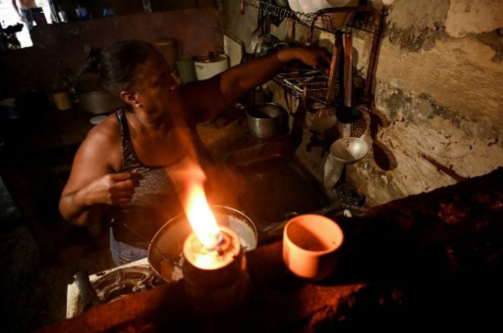 Una mujer cocina en su casa sin electricidad tras el paso del huracán Ian en La Habana.