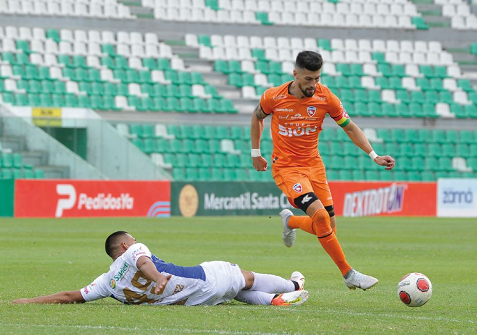 Joel Fernández va al piso en busca de recuperar el balón.