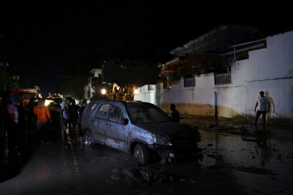 Un automóvil queda atascado en el lodo tras una inundación por fuertes lluvias en El Castaño, Venezuela.