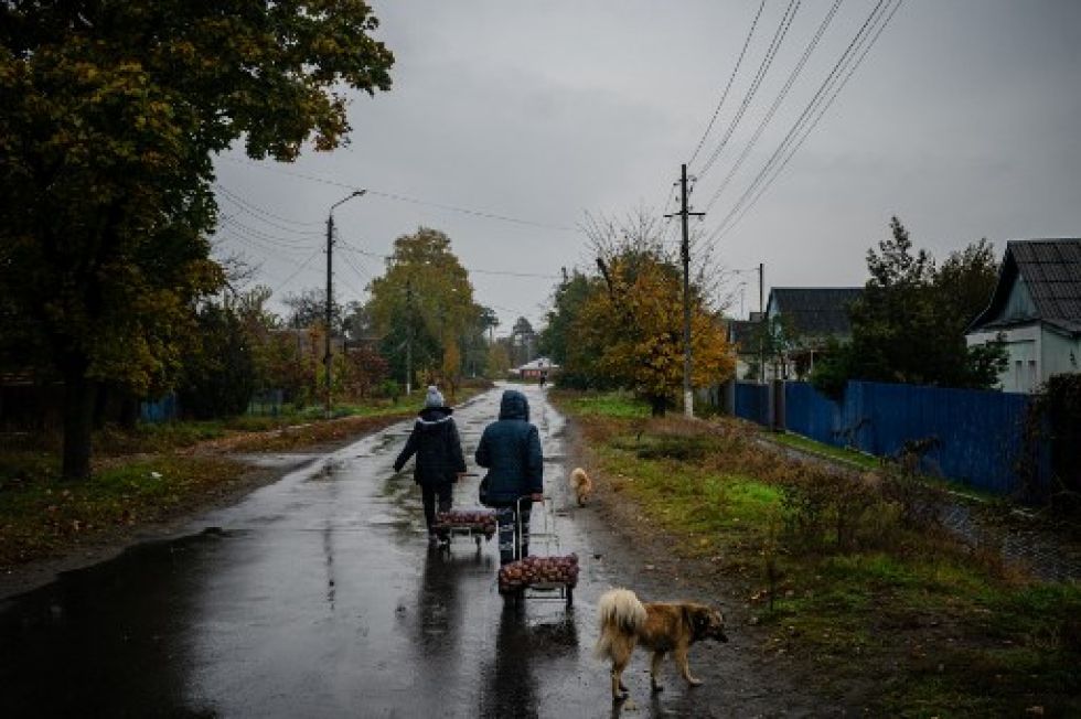 Dos mujeres tiran de carros con papas recibidas como ayuda humanitaria, en Svyatohirs'k, región de Donetsk.