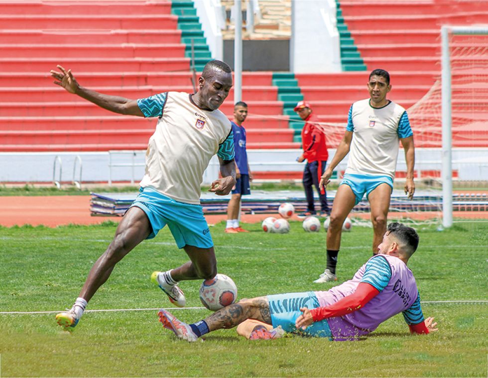El colombiano Jhonatan Franco protege el balón ante la barrida de Miguel Suárez en la práctica de ayer.
