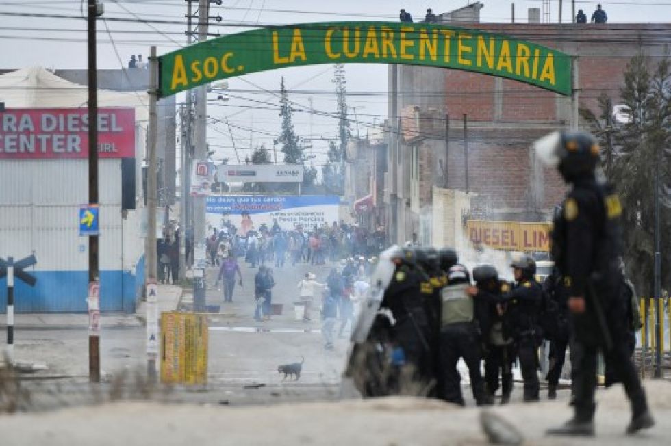 Manifestantes chocan con la Policía antidisturbios durante una protesta en la carretera Panamericana en el Cono Norte de Arequipa, Perú, este lunes.