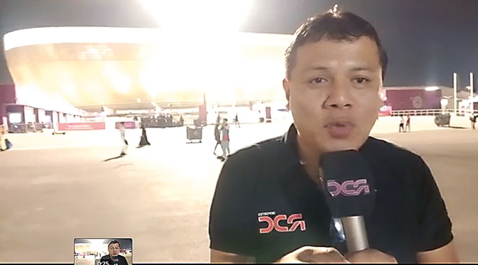El periodista boliviano Mauricio Cambará transmitiendo desde afueras de un estadio qatarí.