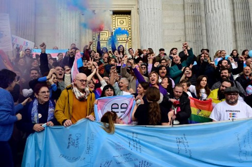 Activistas celebran la votación a favor del proyecto de ley de derechos de las personas transgénero, frente al Congreso de los Diputados de España, en Madrid.
