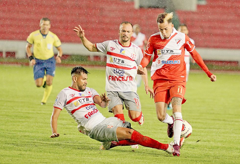 El dominicano Edarlyn Reyes (d) intenta superar la marca de Jorge Toco anoche, en el estadio Patria.