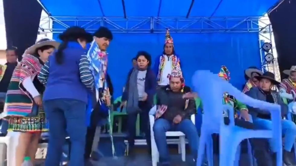 El instante cuando un dirigente indígena sentado en la testera arroja la silla reservada para Morales.